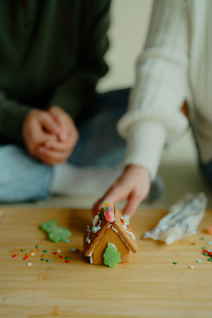 Expecting couple presents their gingerbread house