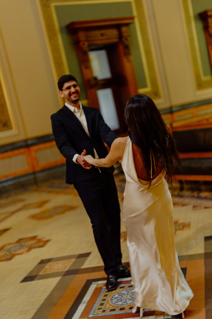 Iowa capitol elopement - groom and bride spinning in circle