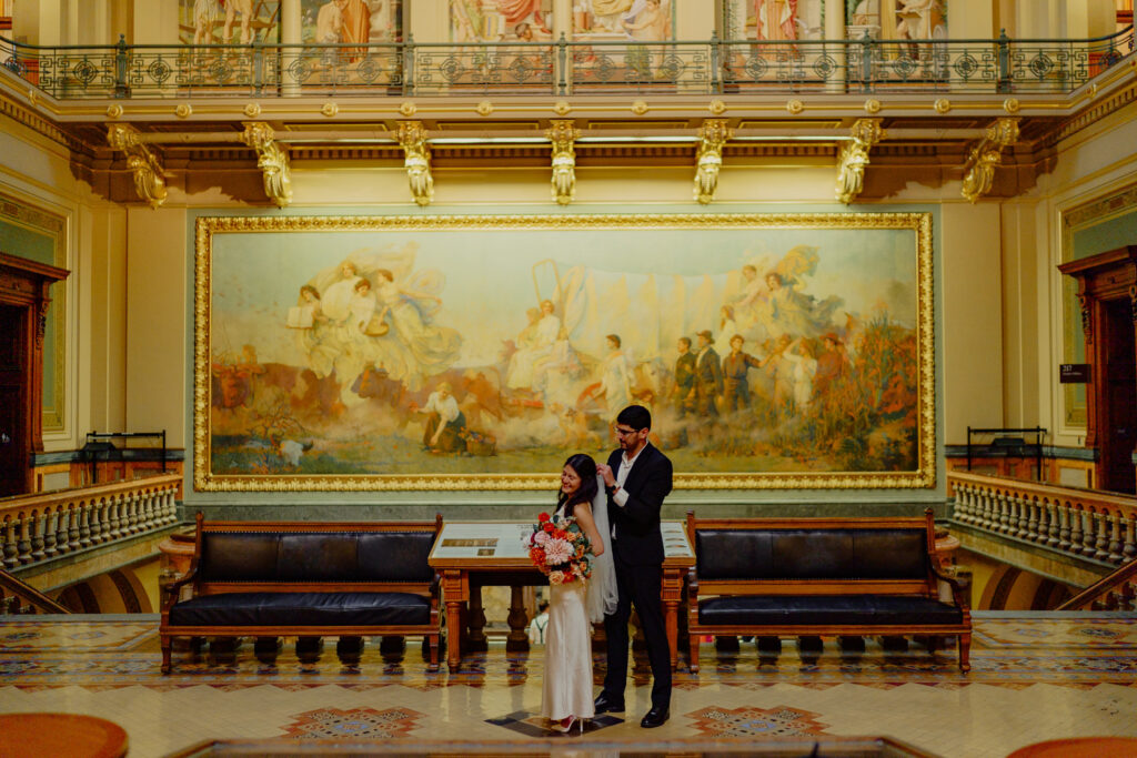 Iowa capitol elopement - groom fixing brides veil