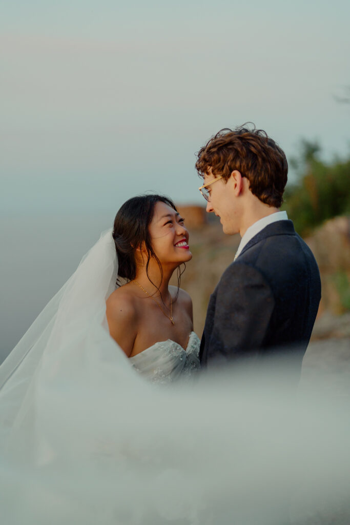 veil shot of eloping couple smiling at each other