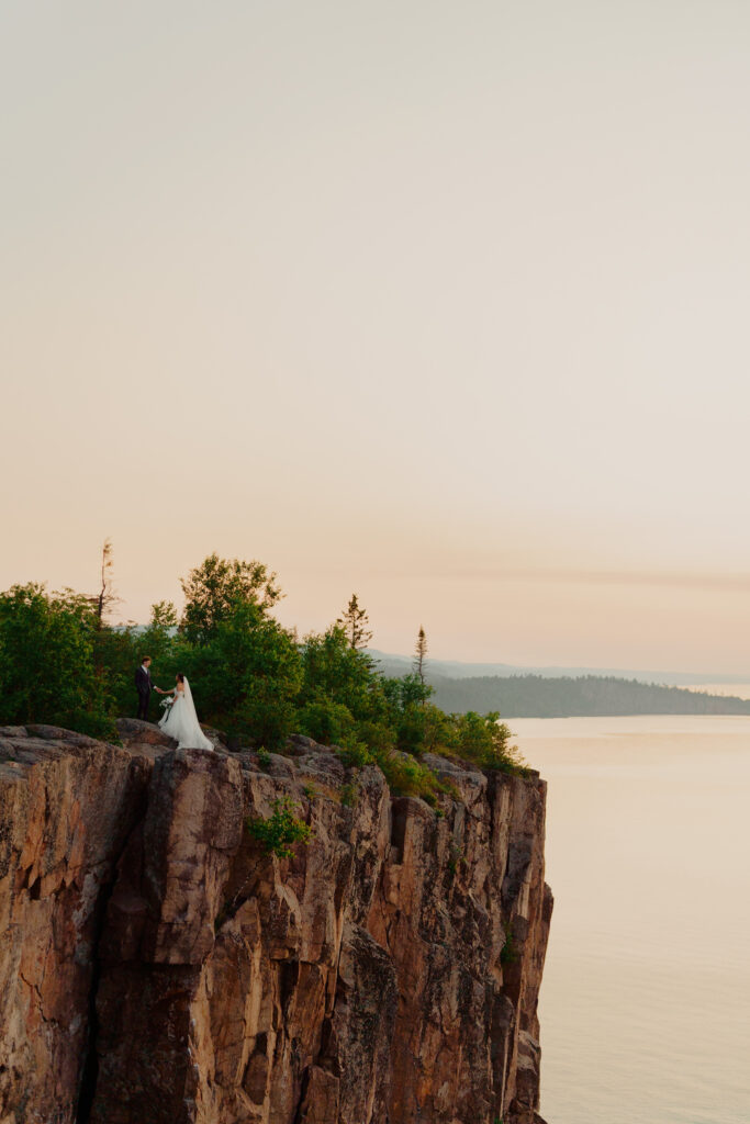 Eloping couple standing against cliffs at palisade head