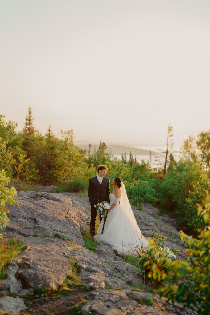 Eloping couple standing side by side as the sun rises