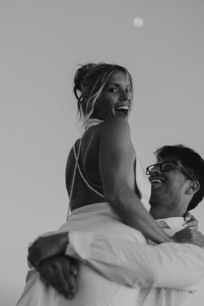 Man holding woman up in the air and couple smiling