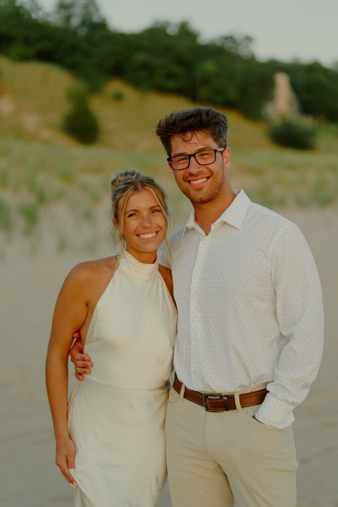 Couple smiling at camera giving each other side hug