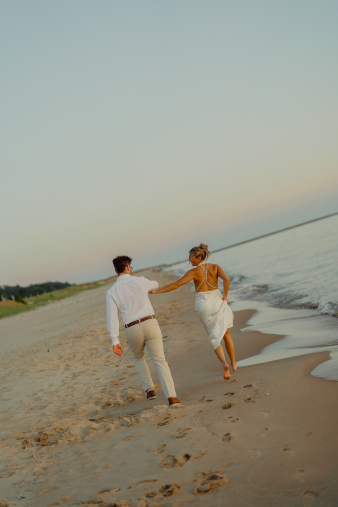 Couple holding hands and walking on beach running