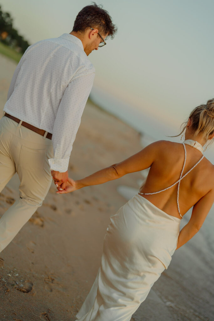 Couple holding hands and walking on beach