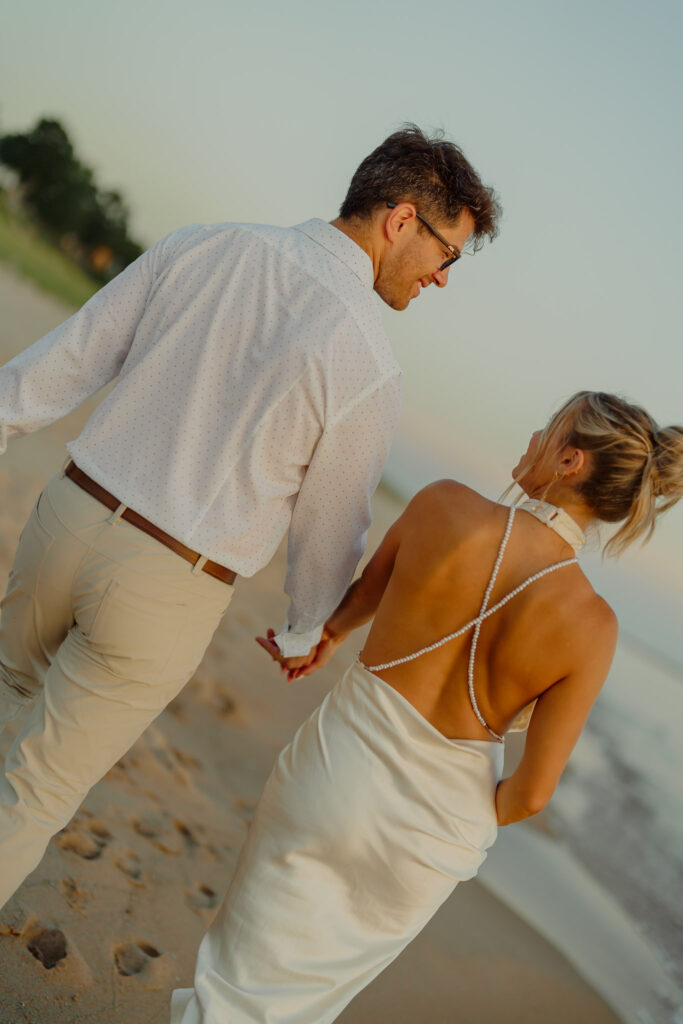 Couple holding hands and walking on beach