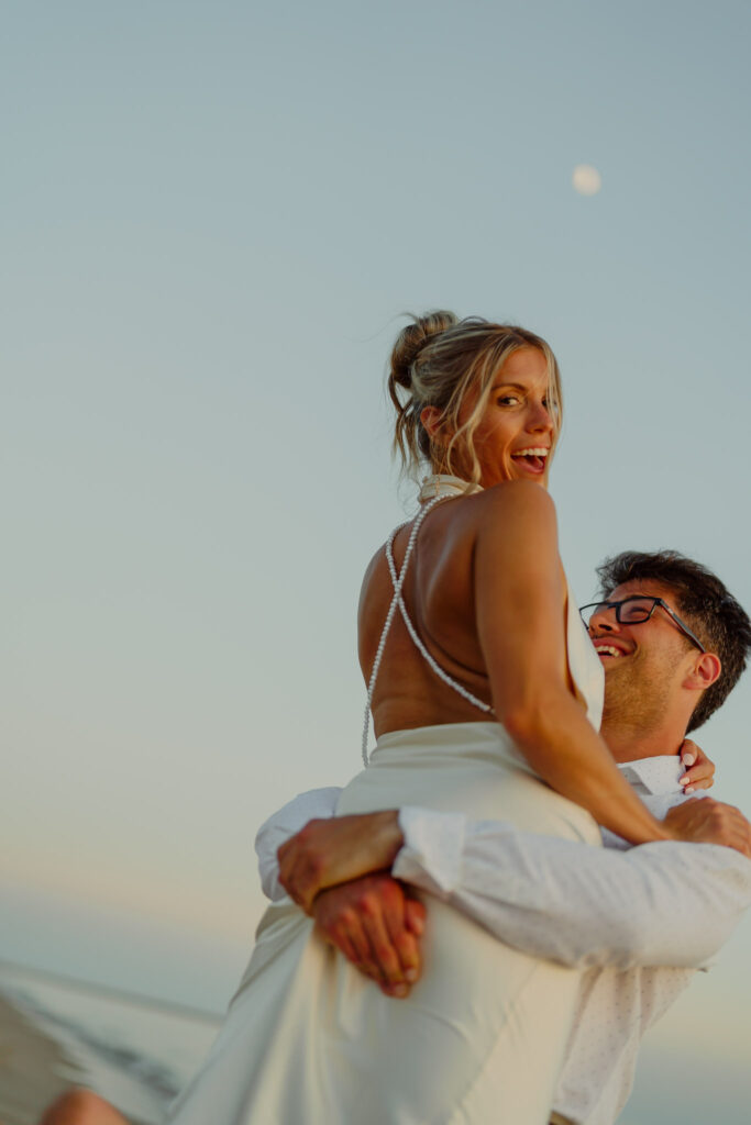 Man holding woman up in the air while woman is smiling