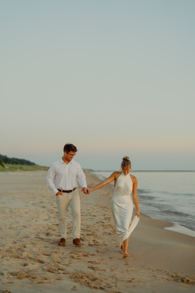 Couple holding hands and walking on the beach at Windsnest Park