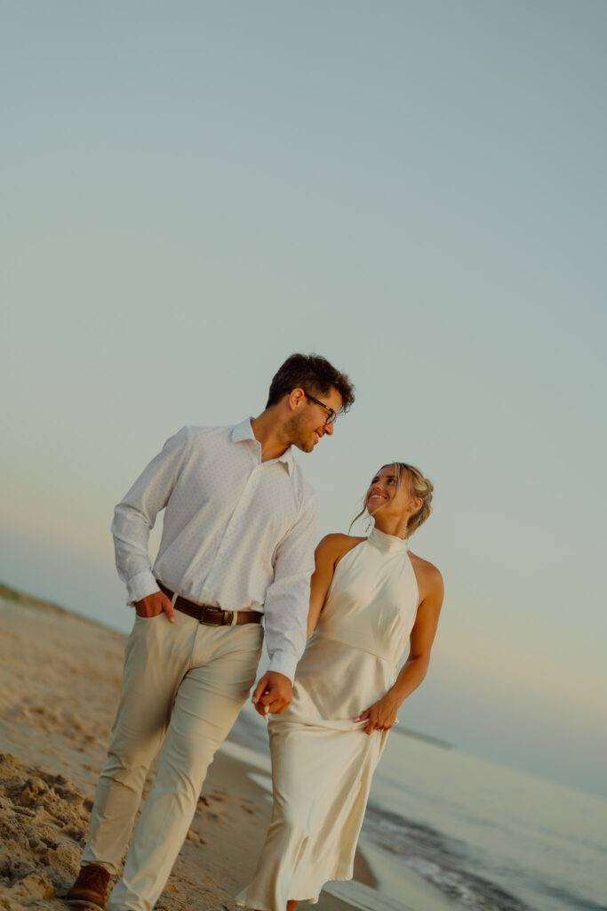 Couple holding hands and walking on the beach