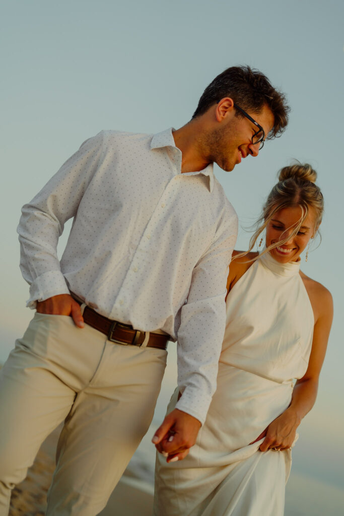 Couple holding hands walking on the beach