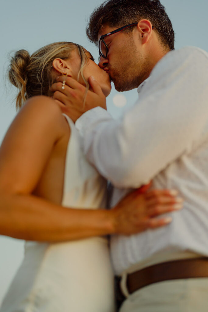 up close couple embracing in tender kiss with moon behind them