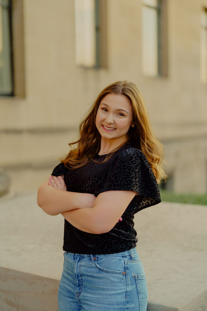 Modern Kansas City business headshots with greenery and marble walls at Nelson-Atkins arms crossed and smiling