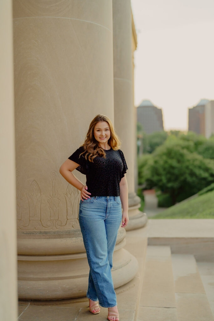 Corporate portrait of woman smiling in natural light at Nelson-Atkins Museum standing by the columns
