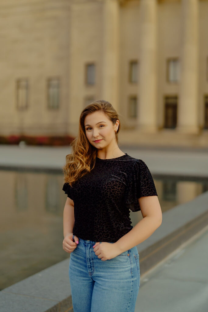 Corporate portrait of woman tight lipped smiling in natural light at Nelson-Atkins Museum