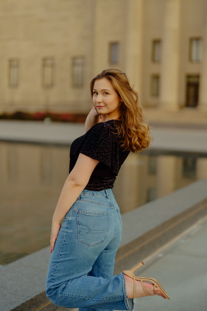 Corporate portrait of woman smiling in natural light at Nelson-Atkins Museum and striking a pose