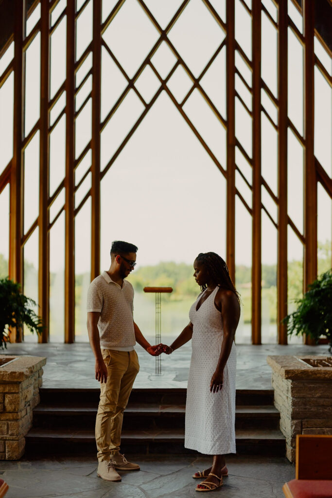Romantic Powell Gardens proposal in Missouri couple holding hands in chapel